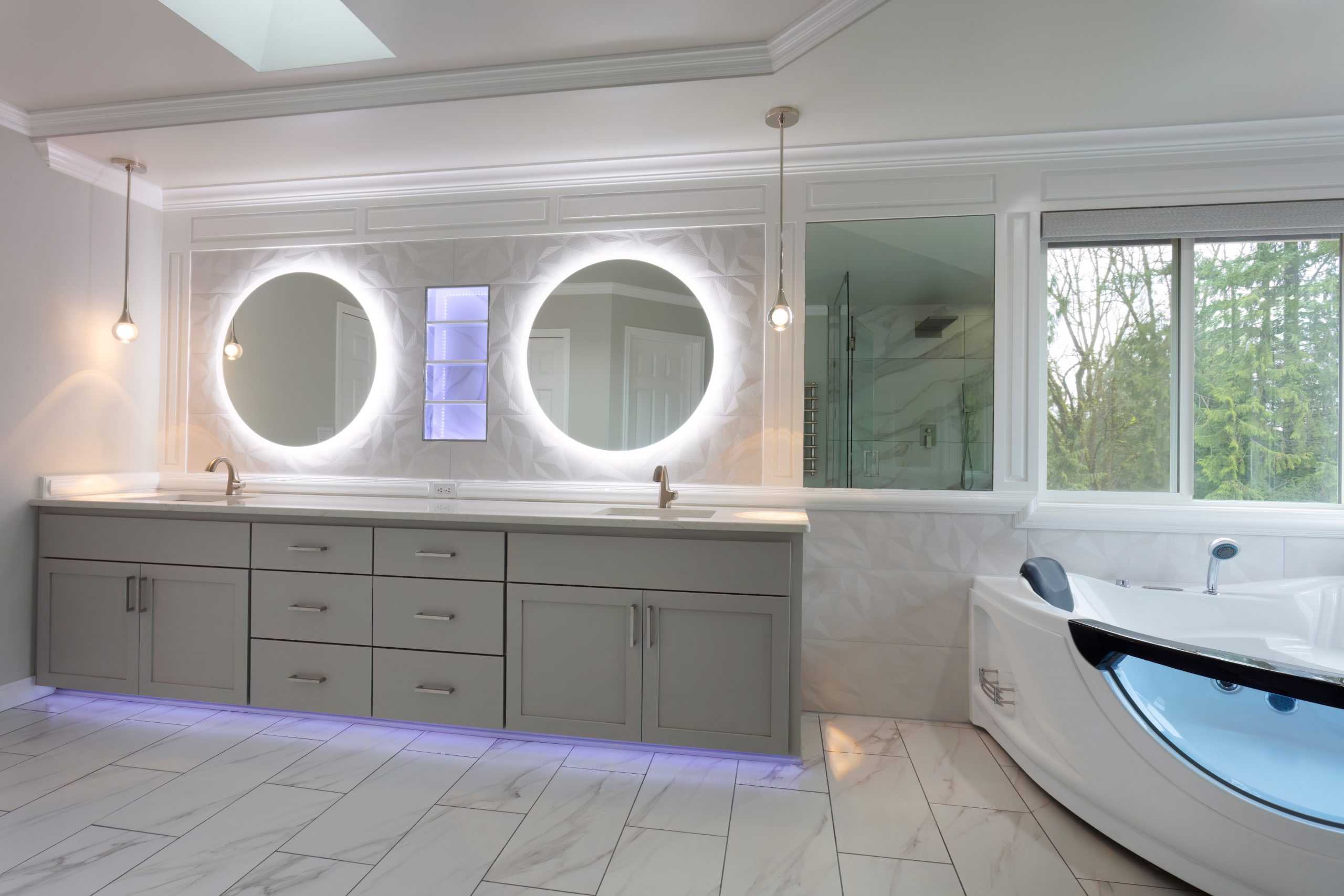 Modern bathroom with large mirrors above a double sink vanity. Recessed lighting illuminates the space, enhancing the sleek design.