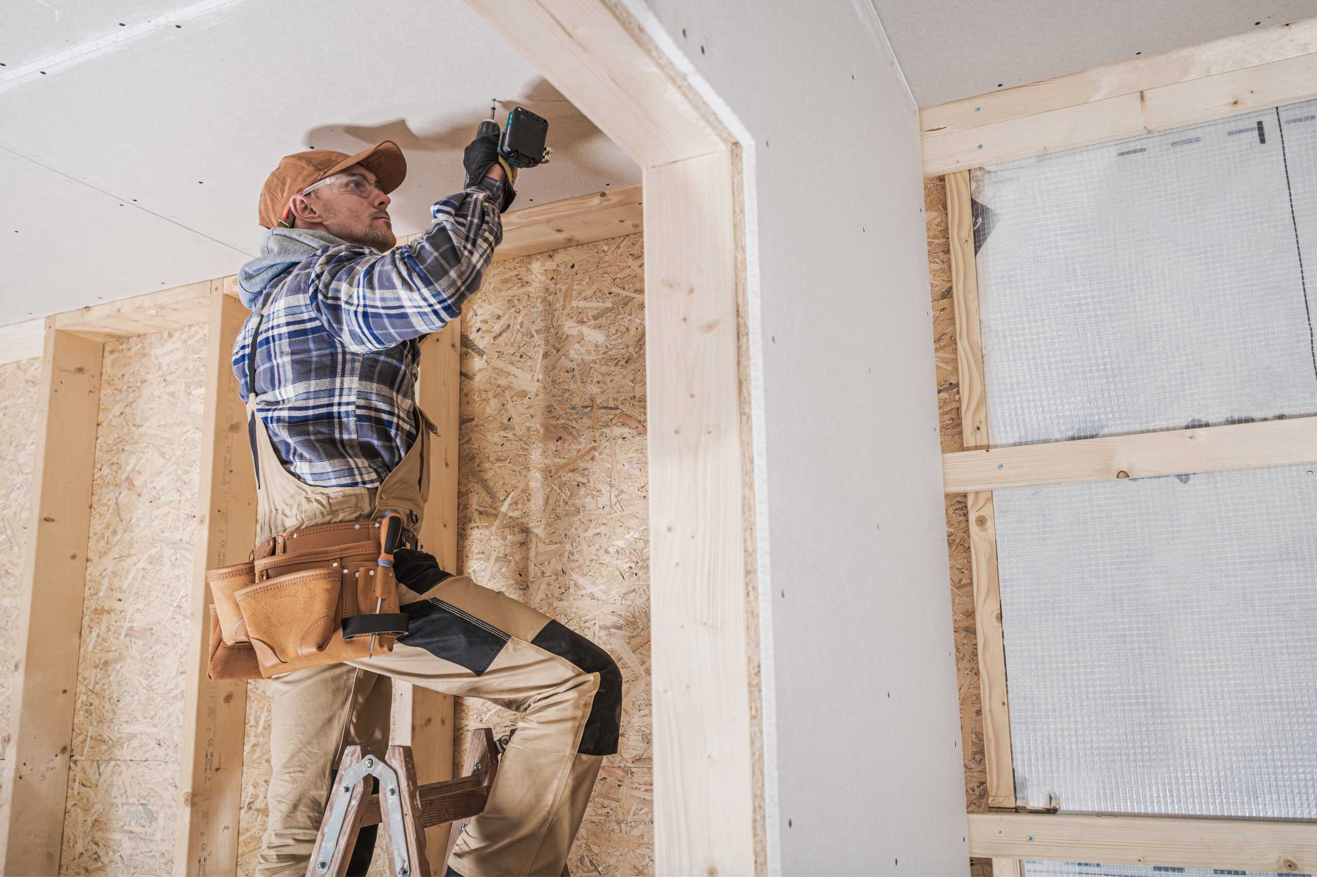 A construction worker in a plaid shirt and cap, part of a General Contractor team in Orange County NY.