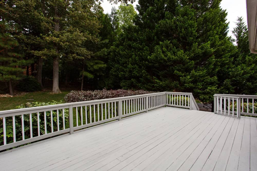 A wooden deck with white railing, crafted by a general contractor in Orange County, NY.