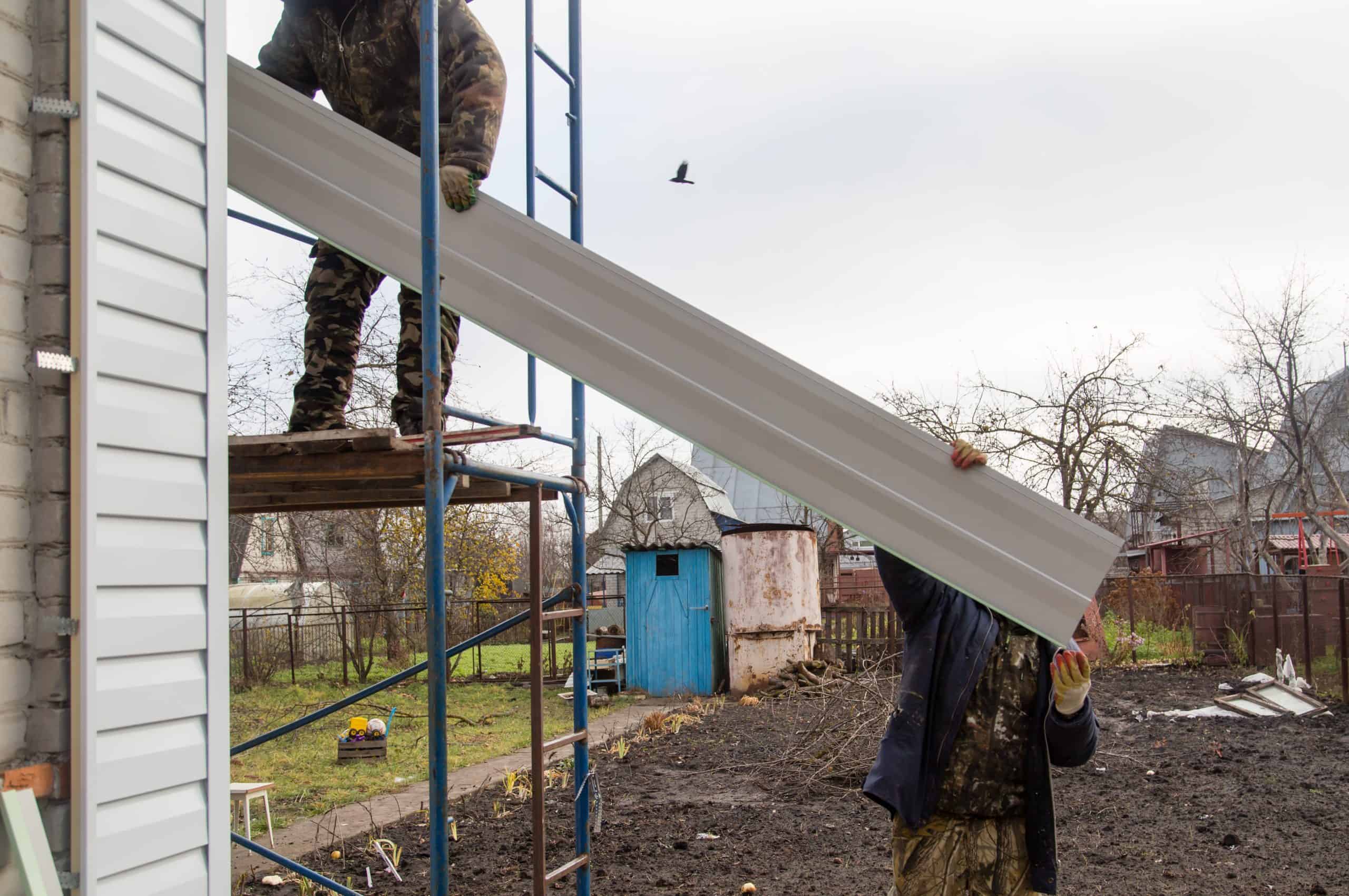 Two workers are handling siding installation in Dutchess County, NY.