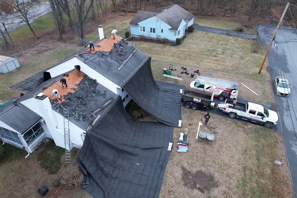 Aerial view of a residential house undergoing roof replacement.