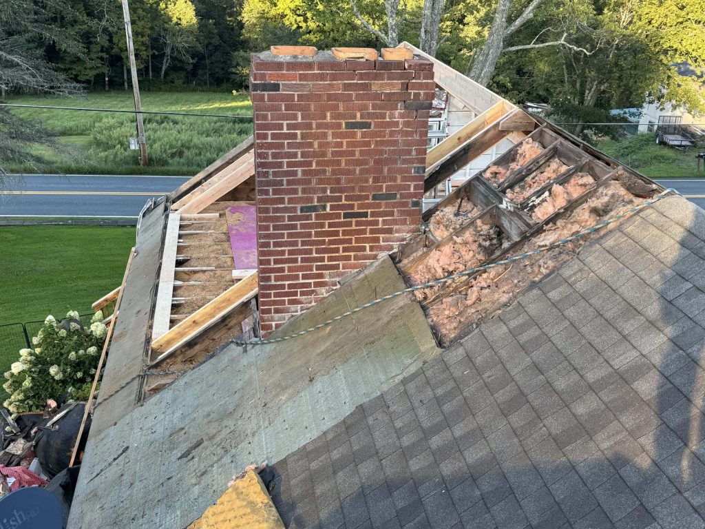 A partially deconstructed roof with a red brick chimney is shown.